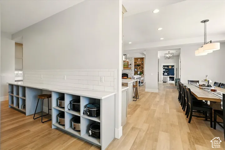 Prep kitchen with built-in cabinetry featuring open shelving and stone-finish countertops, subway tile backsplash