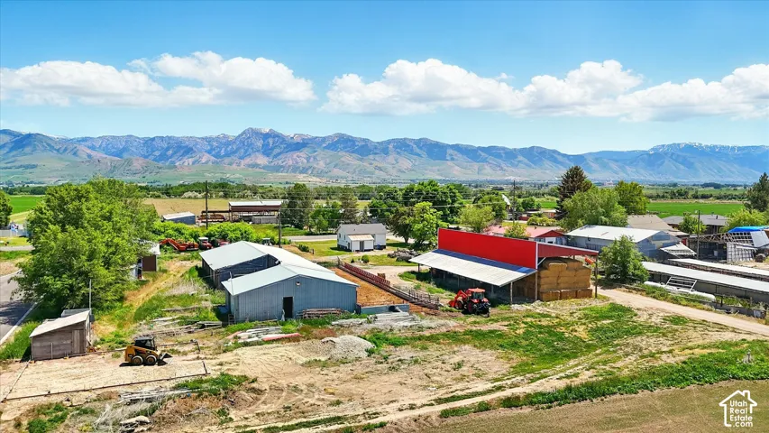 Extensive acreage featuring metal-clad outbuildings, expansive open grounds, and mountain range backdrop