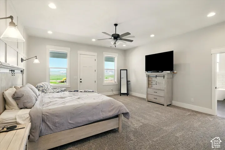 Spacious primary bedroom featuring wall-panel detailing, recessed lighting, a ceiling fan, carpeted flooring, and neutral wall tones