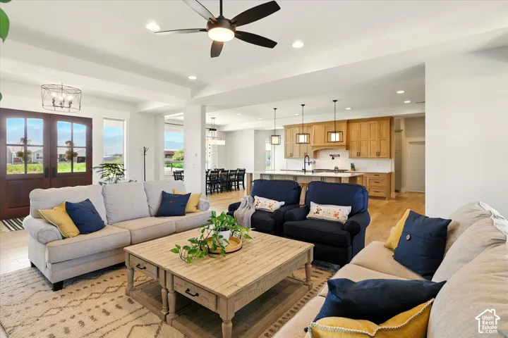 Open floor plan featuring wood-finish tile flooring, recessed lighting, double entry doors, and kitchen cabinetry with a center island