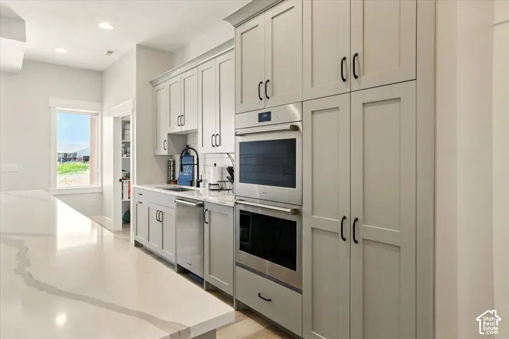 Prep-Kitchen featuring full-height shaker cabinetry, quartz countertops, built-in stainless steel Wolf double ovens, integrated dishwasher, and recessed lighting