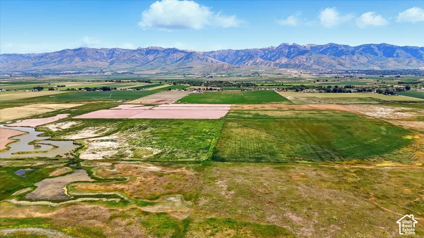 Expansive acreage featuring open pastureland, natural waterways, and a prominent mountain backdrop