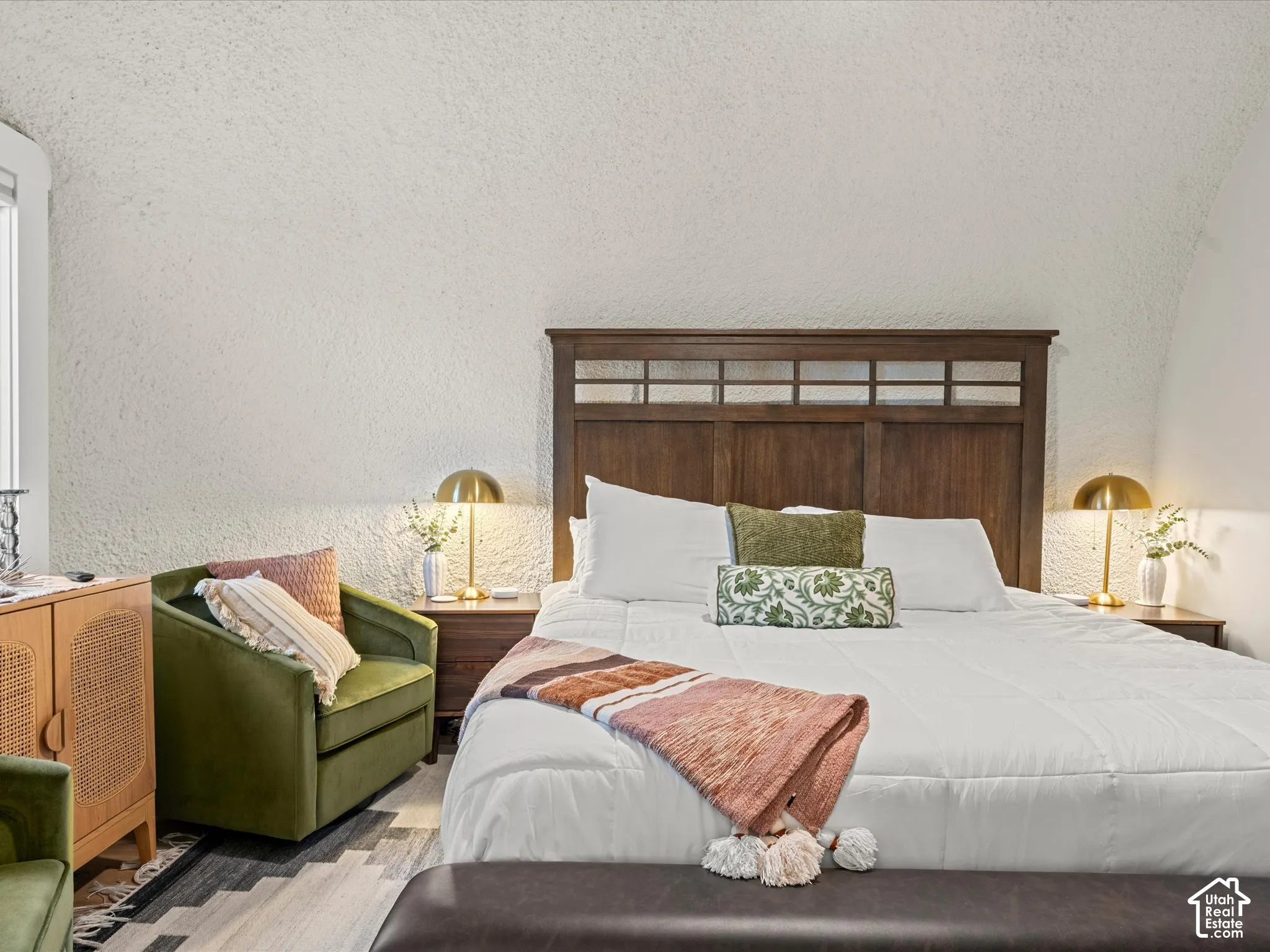 Arched ceiling with textured finish, wood-frame headboard, and dual built-in bedside storage units