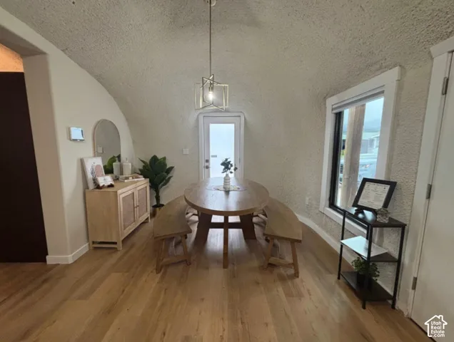 Vaulted barrel ceiling, wood-finish flooring, and geometric pendant lighting