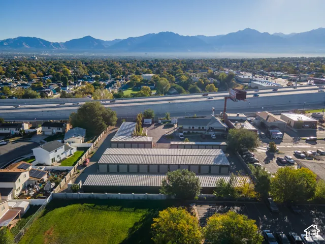 Commercial property featuring multiple storage units, asphalt-paved drive aisles, perimeter fencing, and mountain backdrop