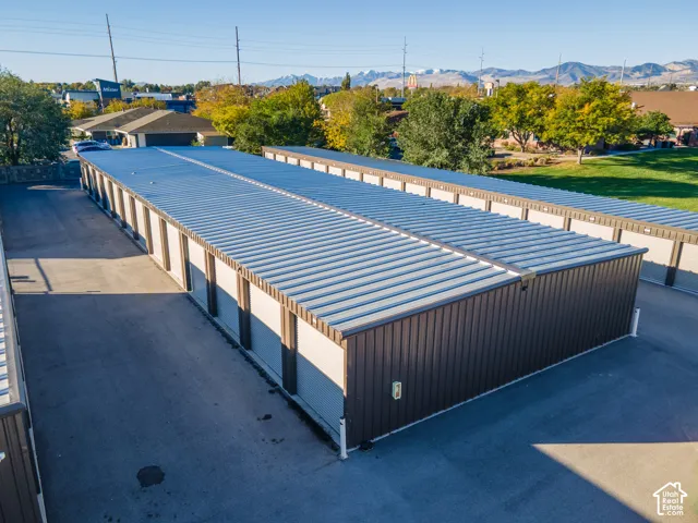Multi-unit storage facility featuring metal siding, standing seam metal roofing, asphalt paving, and individual roll-up doors