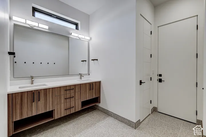 Dual-vanity bathroom featuring a wood-finish floating cabinet, white countertop with dual undermount sinks, horizontal transom window, and matte black hardware
