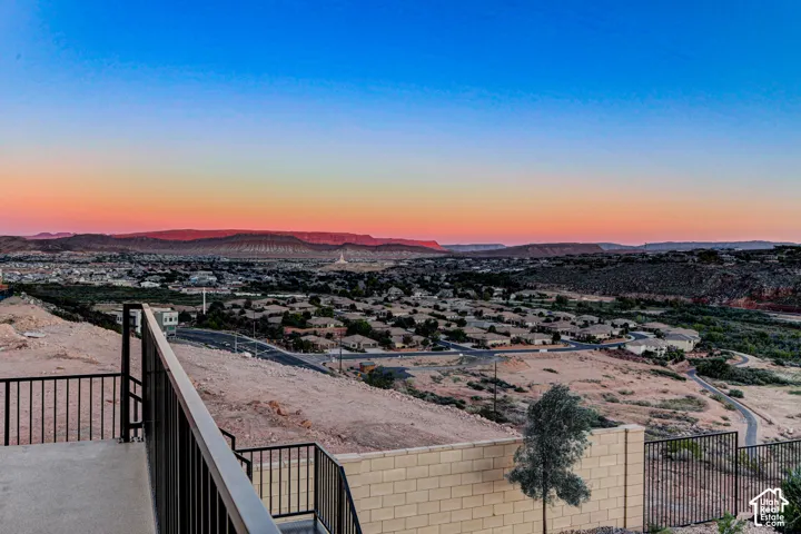 Elevated terrace featuring a black metal railing, concrete block and wrought iron perimeter wall , and extensive desert mountain landscape