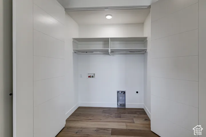 Utility area featuring horizontal plank-style sliding doors, wood-finish flooring, built-in shelving, and recessed ceiling lighting