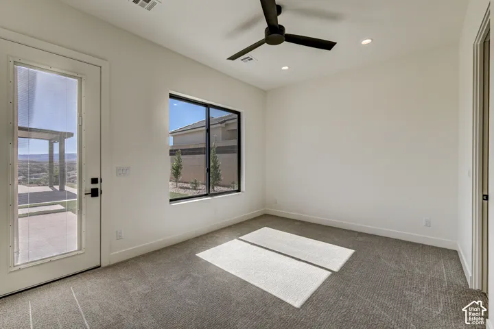 Room featuring neutral wall-to-wall carpeting, recessed ceiling lighting, a matte black ceiling fan, and a exterior door with a glass pane