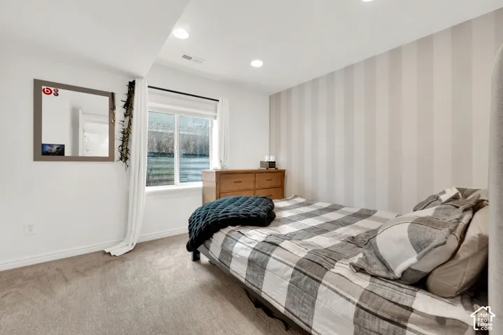 Room featuring recessed lighting, a single window with white trim, and a patterned accent wall
