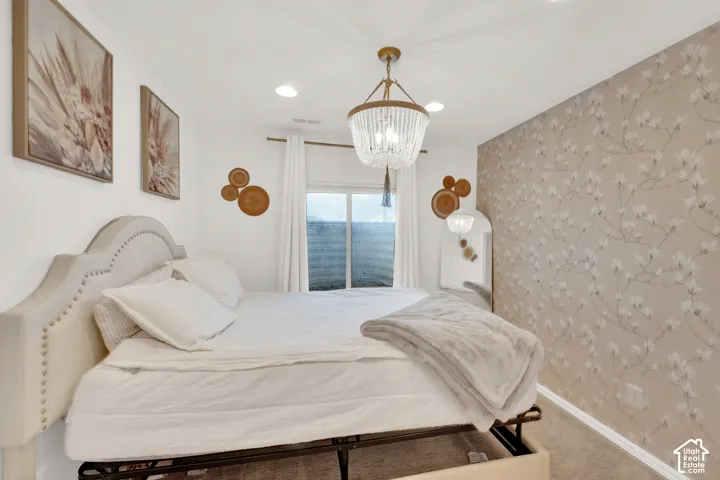 Neutral-toned floral patterned accent wall, tiered beaded chandelier, and recessed lighting