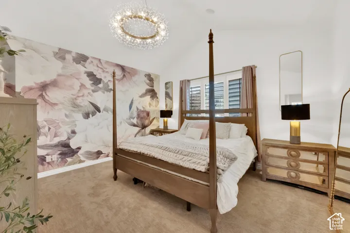 Vaulted ceiling featuring a circular crystal chandelier, custom floral wall covering, and interior window shutters