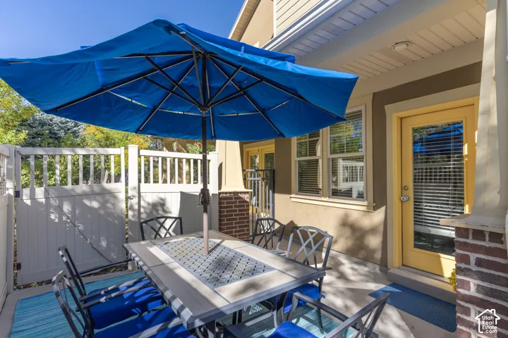 Concrete patio featuring brick-accented columns and white vinyl privacy fencing