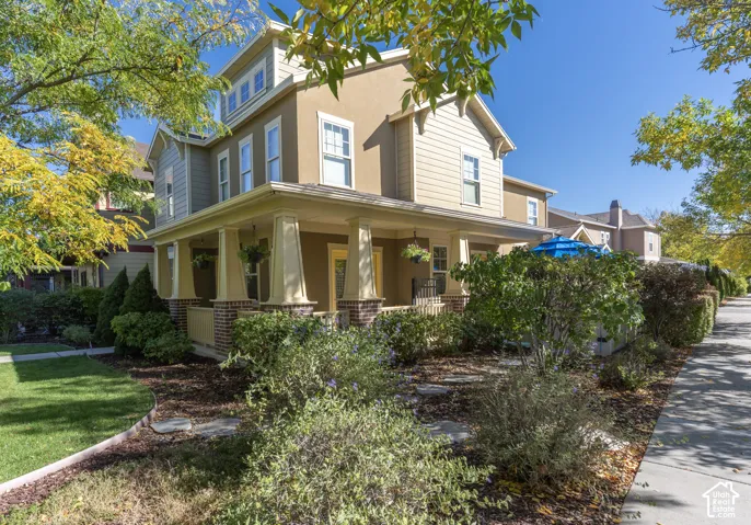 Two-story residence featuring a covered front porch with tapered columns, brick masonry accents, lap siding, and multi-pane windows