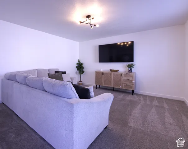 Neutral-toned carpeting, minimalist three-arm semi-flush mount light fixture, and crisp white wall finishes