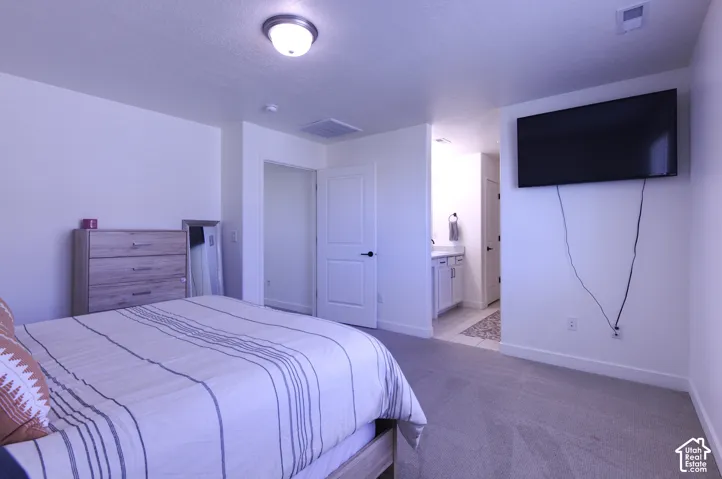 Primary Bedroom. Neutral-toned carpeting, flush-mount ceiling lighting, white interior doors, and solid surface bathroom vanity cabinetry