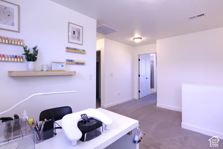Loft area natural wood shelving, neutral-toned carpeting, and crisp white interior walls