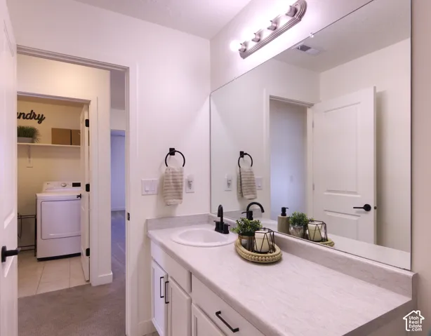 Hall Bathroom vanity featuring white cabinetry, a neutral-toned countertop with an integrated basin, matte black hardware, and a full-width vanity mirror