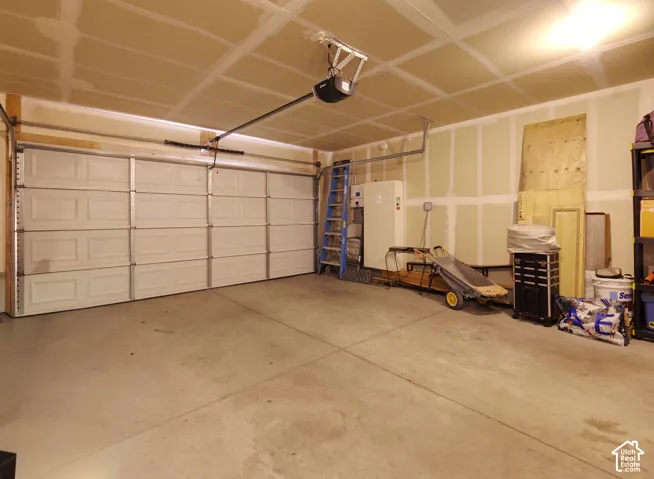 Two-car garage featuring a sectional overhead door, concrete flooring, and ceiling-mounted automatic door opener