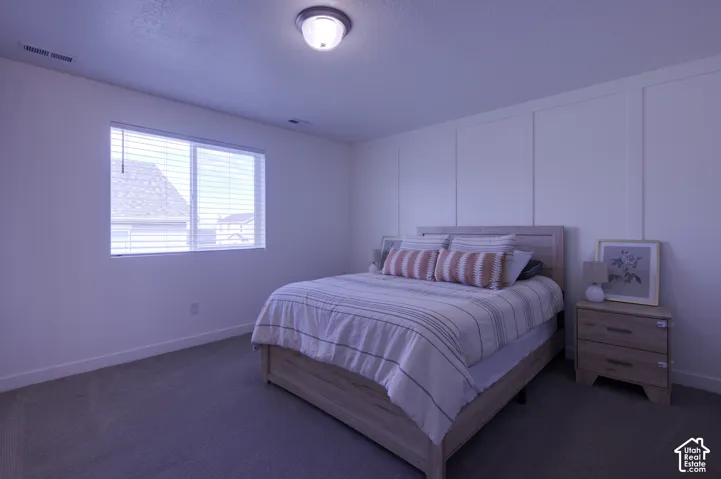 Room featuring wall-to-wall carpeting, window with blinds, and decorative grid-pattern wall molding