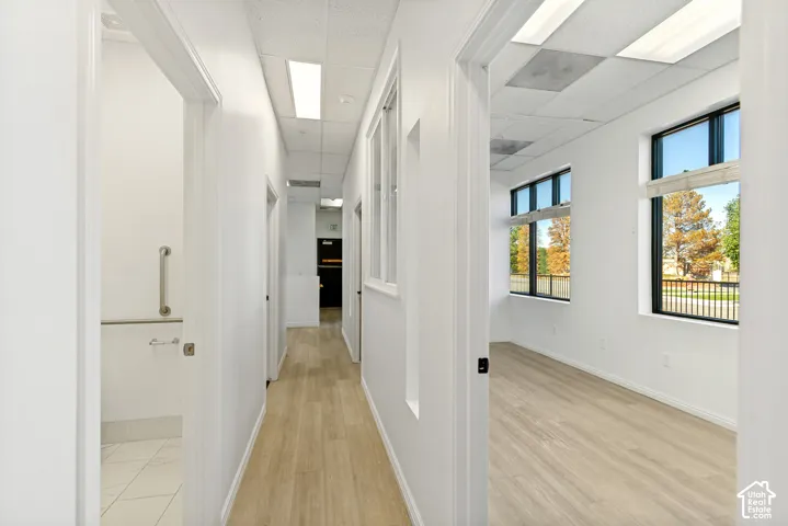 Interior hallway featuring wood-finish flooring, recessed lighting, and large windows with black frames