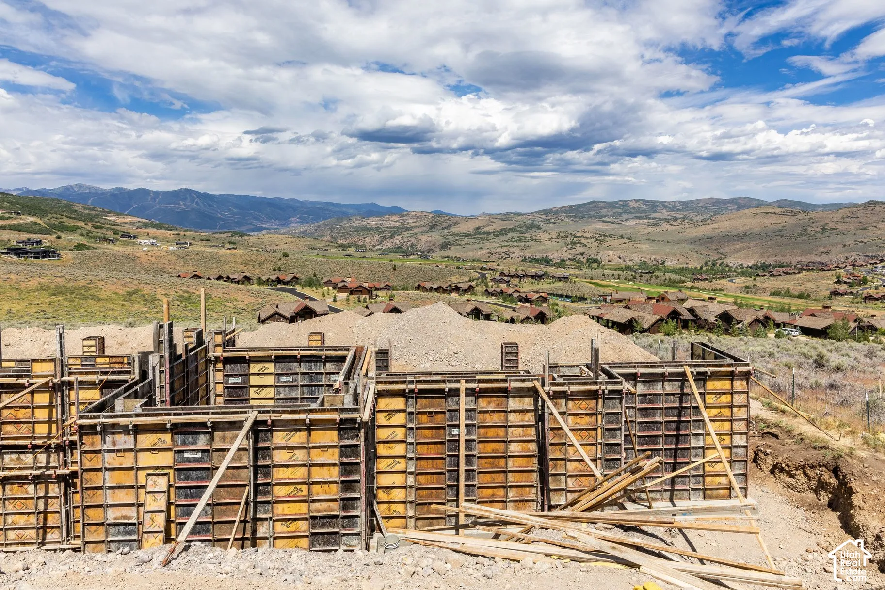 Foundation structure with metal forming panels, set against a backdrop of mountainous terrain and horizon scenery