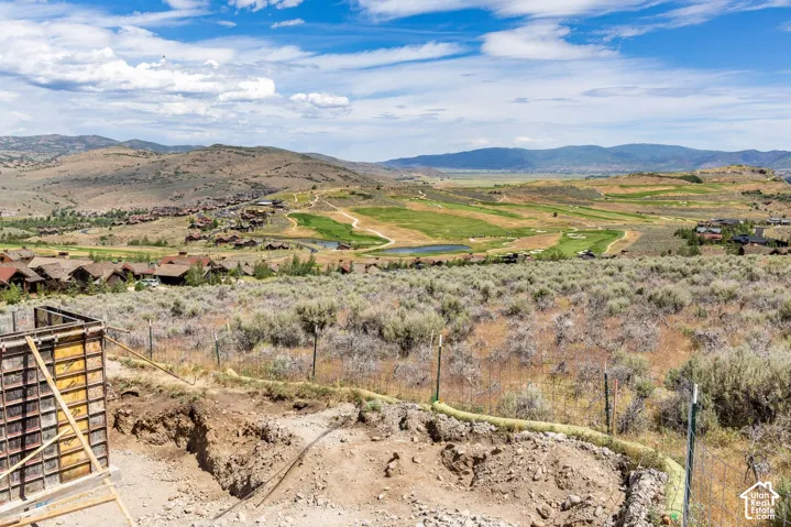 Elevated land featuring native brush, a construction foundation, and panoramic mountain and valley scenery