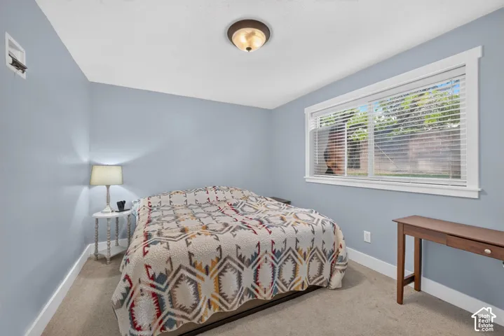 Neutral-toned wall paint, neutral carpeting, and a wide window with a multi-pane horizontal blind