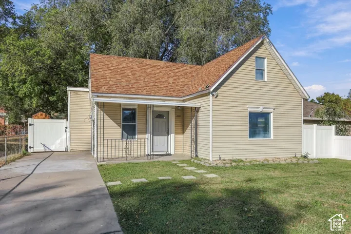 Exterior featuring horizontal siding, asphalt shingle roofing, a concrete driveway, and white vinyl privacy fencing