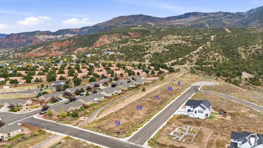 Elevated residential building lots featuring paved street access, utility infrastructure, and panoramic mountain backdrop