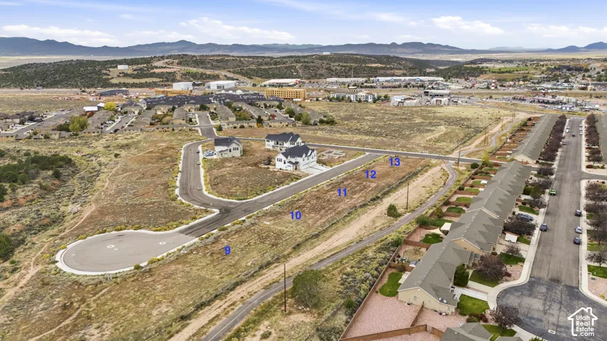 Expansive residential lots featuring asphalt street access, underground utility infrastructure, and mountain terrain backdrop