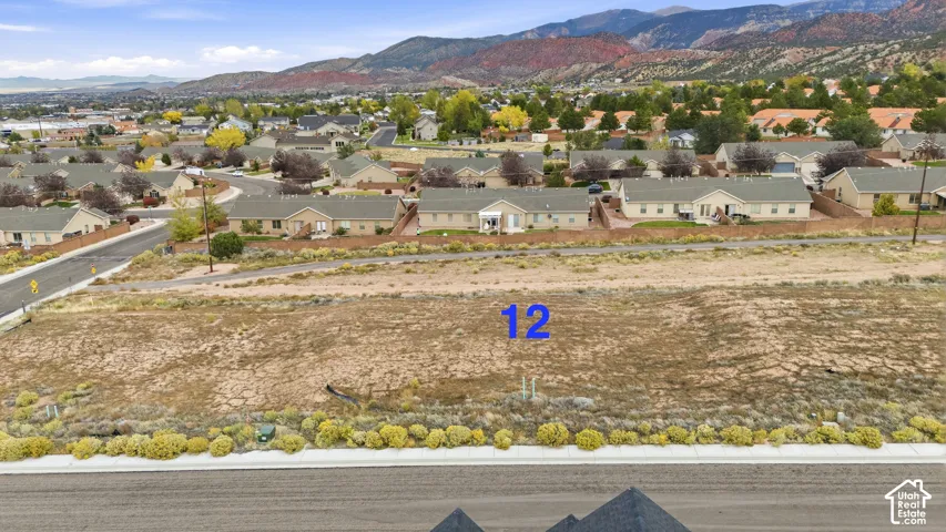 Cleared residential parcel featuring paved street access and mountain backdrop