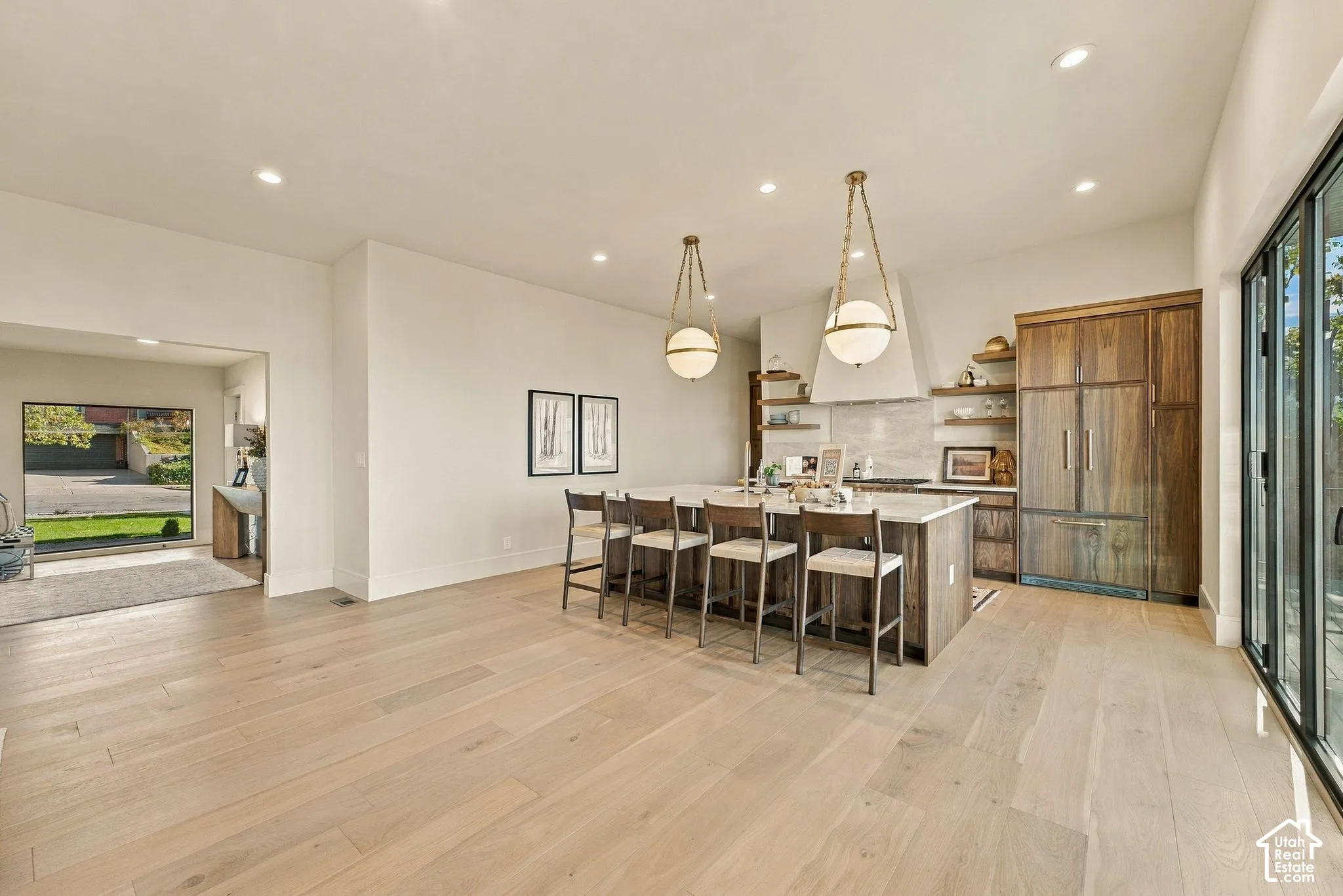 Kitchen featuring a center island with bar seating, custom wood-finish cabinetry, recessed lighting, and wood-finish flooring throughout