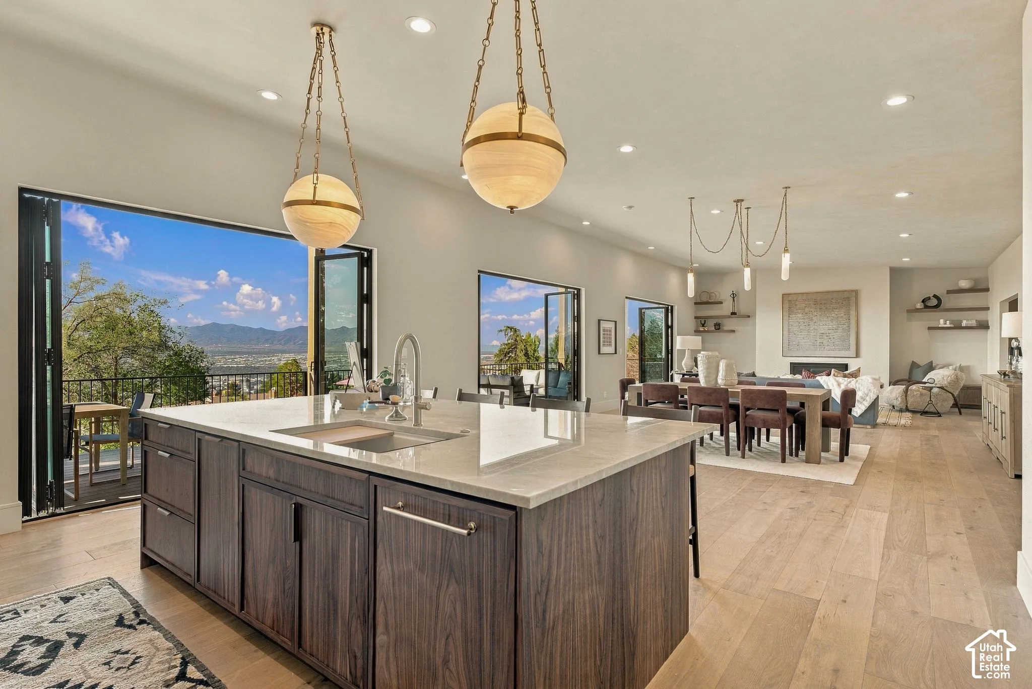 Kitchen island featuring dark wood cabinetry, a light-toned solid surface countertop, and an undermount sink