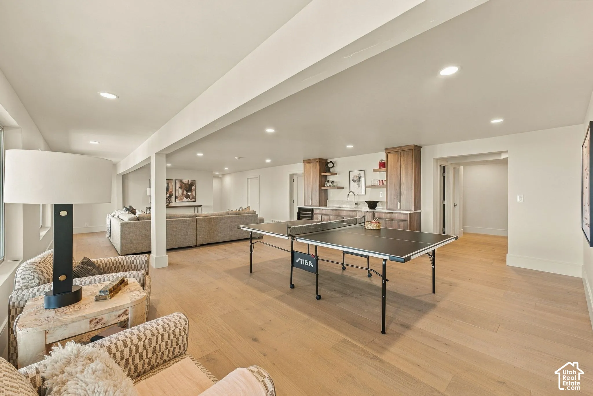 Open-concept living space featuring wood-finish flooring, recessed lighting, and a built-in wet bar with cabinetry and open shelving
