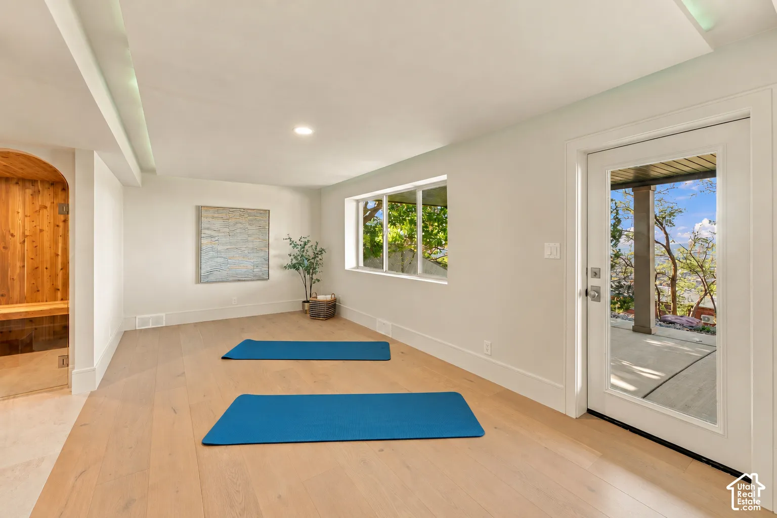 Wood-finish flooring, recessed lighting, built-in cedar sauna with glass door, and glass-paneled exterior door