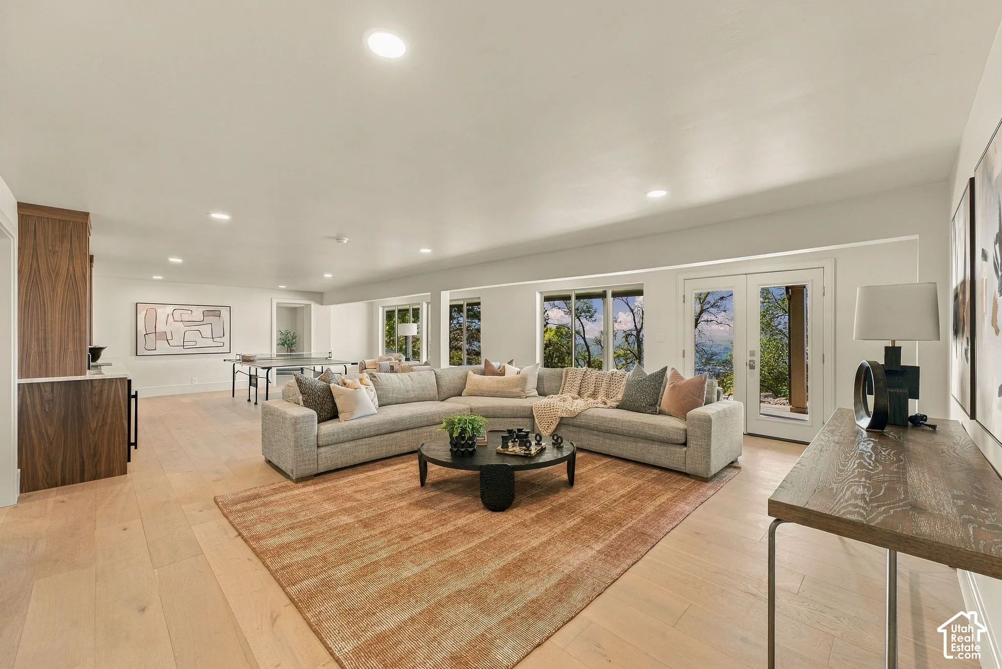 Open-concept living space featuring recessed lighting, wood-finish flooring, built-in cabinetry, and double glass-paneled exterior doors