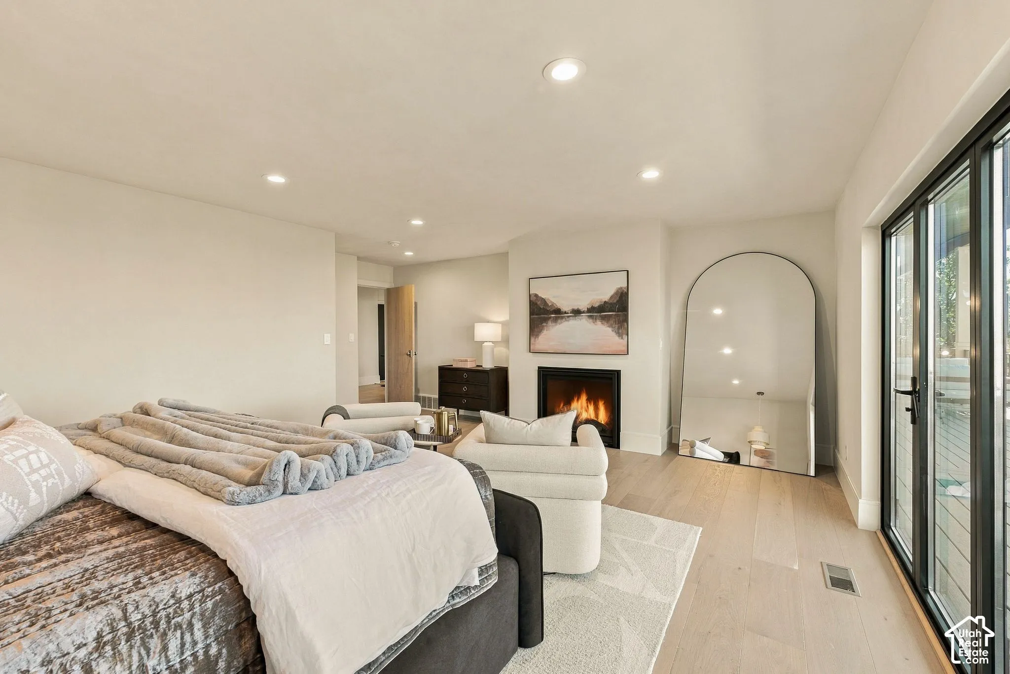 Recessed lighting, wood-finish flooring, built-in fireplace, and expansive multi-panel glass door