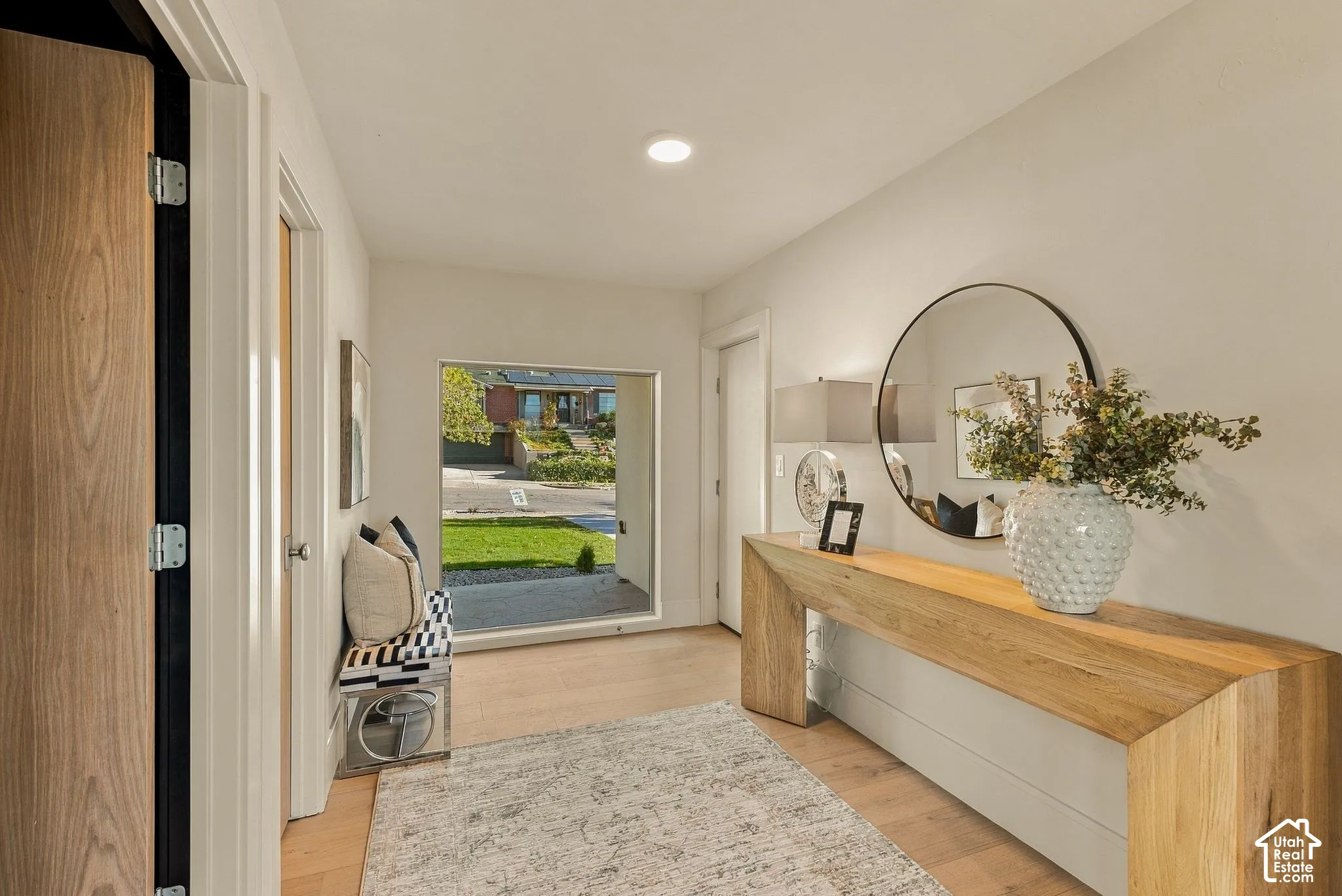 Entryway featuring light wood-finish flooring, a rectangular picture window, neutral wall paint, and recessed lighting