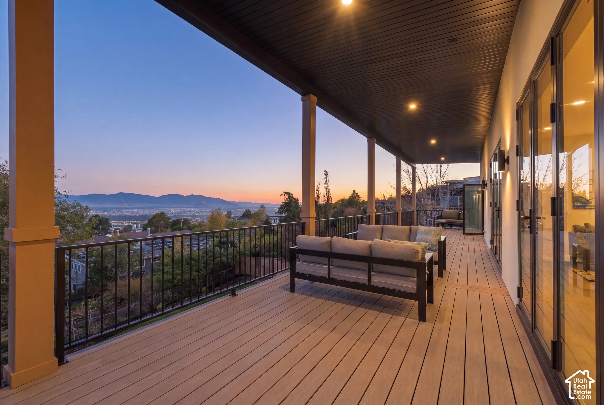 Covered deck featuring composite decking, metal railings, recessed lighting, and expansive mountain scenery