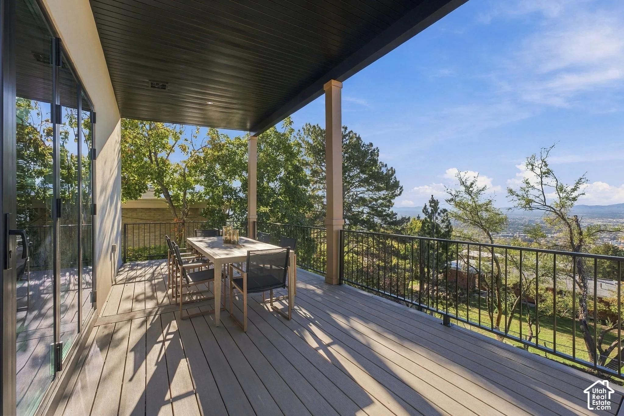 Covered deck featuring composite decking, black metal railing, and recessed ceiling lighting
