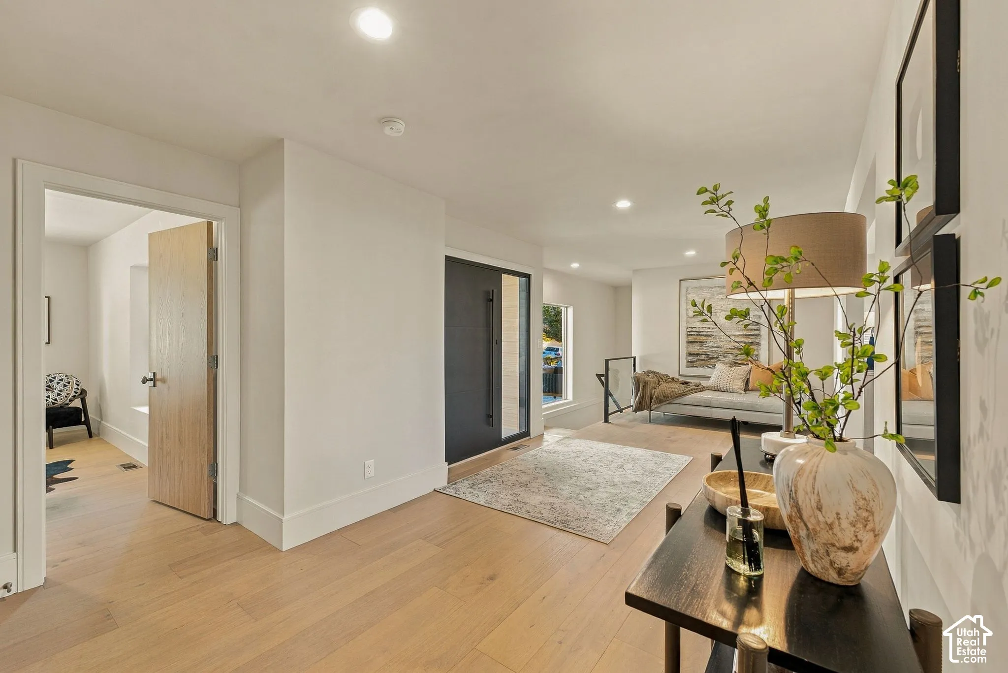 Entryway featuring light-toned wood-finish flooring, recessed lighting, and a dark-finish entry door with a side glass panel