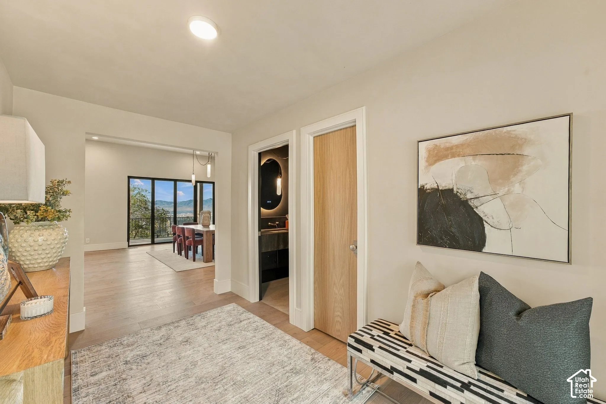 Interior hallway featuring neutral wall paint, wood-finish flooring, and a natural wood-veneer door