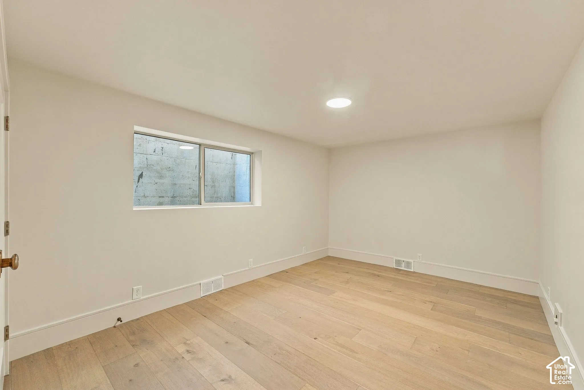 Interior space featuring wide-plank wood-finish flooring, neutral wall tones, and recessed ceiling lighting