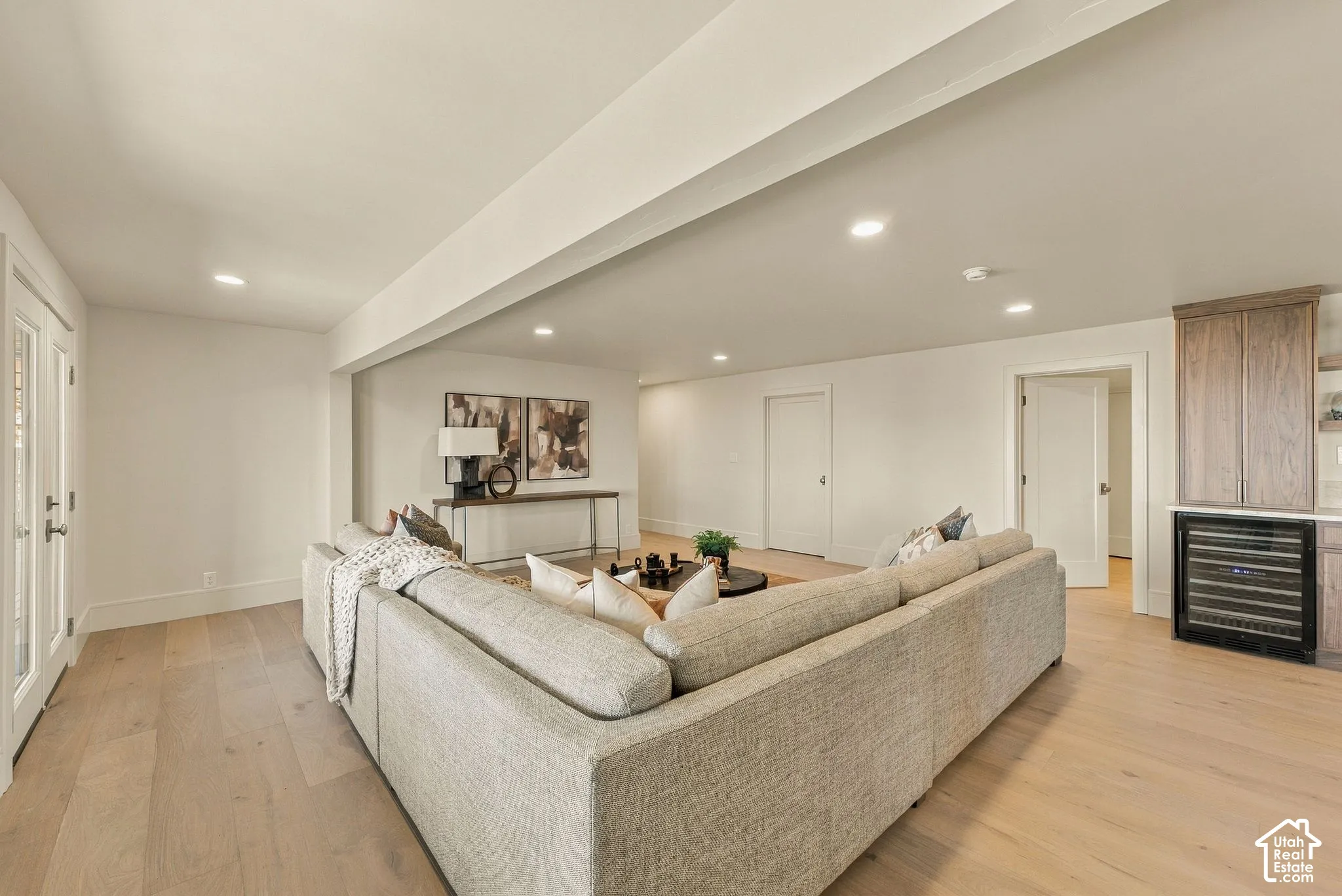 Open-concept room featuring wood-finish flooring, recessed lighting, and a custom built-in beverage refrigerator cabinet