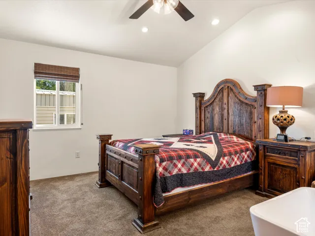 Vaulted ceilings, neutral wall color, recessed lighting, ceiling fan with integrated light fixture, and textured carpeting
