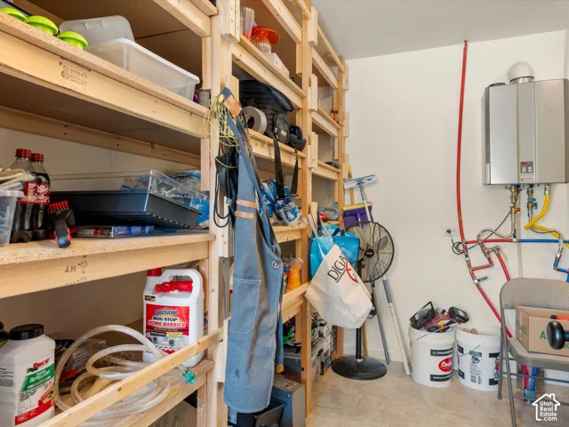 Wall-mounted tankless water heater featuring exposed copper and PEX plumbing lines, accompanied by floor-to-ceiling custom wood shelving units