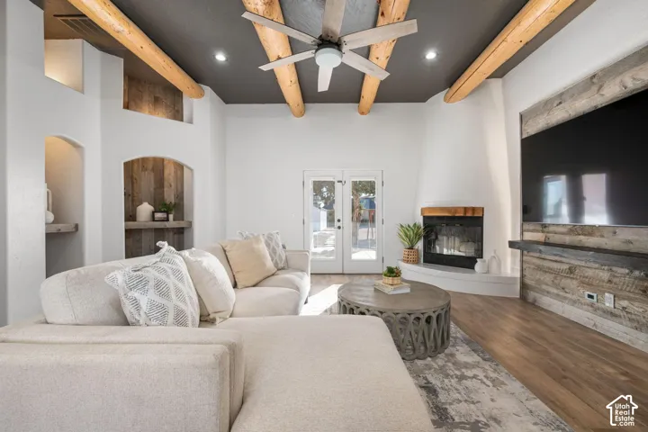 Exposed log ceiling beams, recessed wall niches, floor-to-ceiling wood-plank accent wall, and a fireplace with a raised hearth
