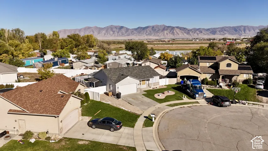 Aerial perspective of residential lots featuring paved driveways, attached garages, and a mountain range backdrop